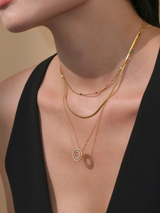 Detalle de collar multicapa chapado en oro de 18k con cuentas de colores y dije de circón