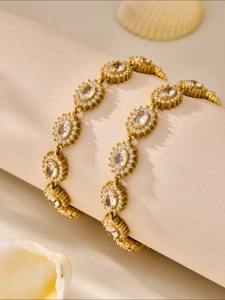 Detailed view of a gold chain bracelet with oval 5A zircon and halo stone setting