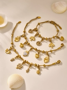 Detalle de los colgantes de acero inoxidable bañados en oro de 18k y pulseras árbol de vida
