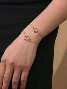 Primer plano de la pulsera de doble anillo bañada en oro de 18k con circonitas brillantes
