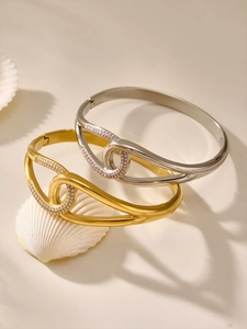 Close-up of gold and silver open bracelets with interlocking pavé zircon circles