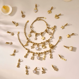 Goldenes Edelstahl-Herzarmband mit Zirkonia-Anhängern auf elegantem Hintergrund