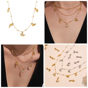 Detailed macro view of 18k gold plated layered dolphin and sea turtle necklaces