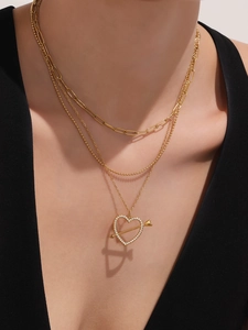 Detailed view of layered gold necklace with crystal-studded heart pendant and mixed chains
