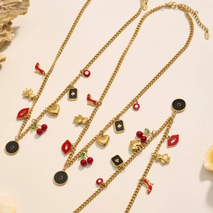 Collana in acciaio inox dorato con tacchi alti rossi e ciondoli a ciliegia su fondo bianco