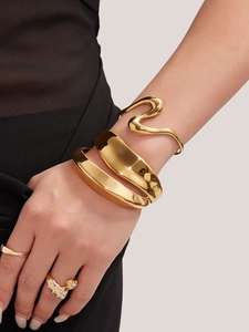 Primer plano de brazaletes y anillos apilables de acero inoxidable bañados en oro 18k
