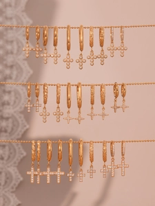 Gros plan détaillé de boucles d'oreilles croix en or 18k avec pavé de zircons 5A