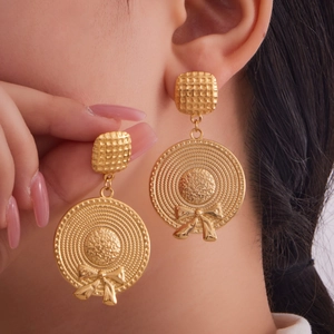 18k gold plated stainless steel bow hat chain earrings worn by a model in soft light