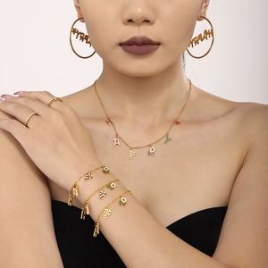 Dettaglio del set di gioielli natalizi con ciondoli smaltati su modella con collana e orecchini