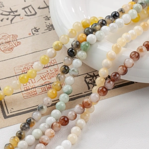Macro shot of 6-8mm polished natural jade beads with colorful stone patterns and wax luster