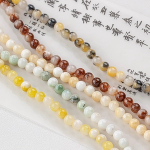 Detailed view of polished natural jade beads in tea-milk tones for DIY jewelry making