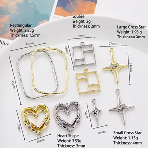 Assorted gold and silver geometric DIY pendants with star and heart motifs on white ceramic
