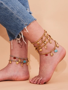 Macro shot of bohemian layered anklets with ocean charms like starfish and shells