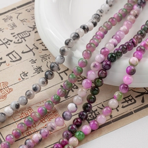 Macro detail of mixed color natural stone beads for DIY jewelry on white porcelain