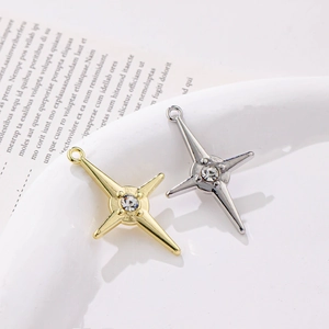 Star-shaped gold and silver pendants with central rhinestones on a white plate
