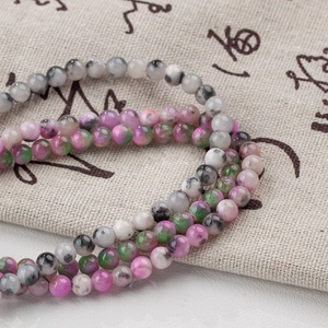 Detail of 4-12mm multi-color natural stone beads on rustic linen fabric for DIY jewelry