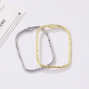 Detailed view of irregular hammered rectangular metal frames in gold and silver colors