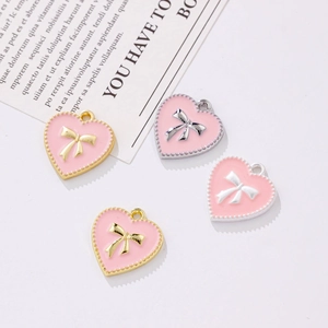 Pendentifs cœur en émail rose avec nœud doré et bords perlés pour la création de bijoux