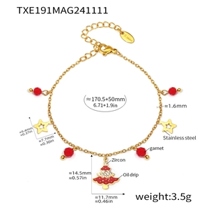 Detail of gold stainless steel bracelet with red beads and zircon Christmas tree charm