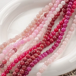 Nahaufnahme polierter Naturjadeperlen in Rosarot und Pink für DIY-Schmuckherstellung