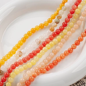 Macro shot of 4-6mm natural yellow jade beads for DIY jewelry making in a white ceramic dish