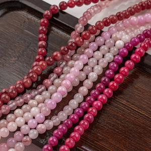 Fuchsia Naturjade Rundperlen für DIY-Schmuck auf einem Holztablett präsentiert