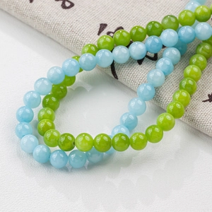 Detail view of 8mm round blue and green natural jade beads with a smooth polished finish