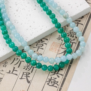 Detailed view of 4-12mm smooth teal and green natural jade beads for jewelry making