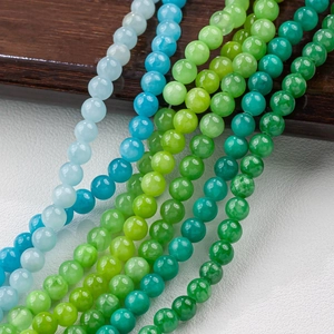 Macro view of polished 4-12mm blue and green round natural jade beads for DIY jewelry