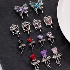 Detailed view of silver liquid alloy charms with heart, butterfly and rose motifs