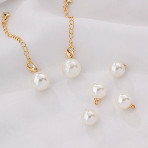 ABS imitation pearl charms with gold lobster clasps and star pendants on white fabric