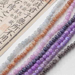 Macro shot of colorful round jade beads in grey, amber, and purple for DIY jewelry crafts