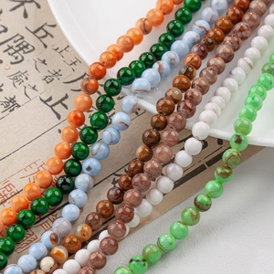 Dettaglio di perle tonde in giada naturale a strisce colorate per la creazione di gioielli