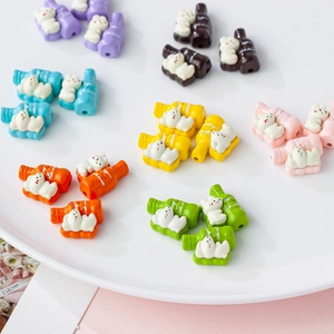 Macro shot of colorful resin bear bottle beads for DIY crafts in a white ceramic bowl