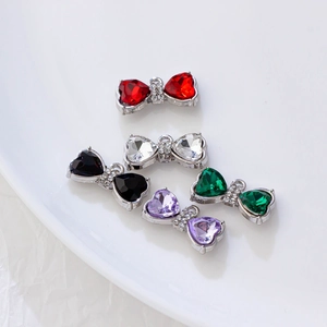 Pendentifs nœud cœur en zircon en cinq couleurs sur un plateau en céramique blanc