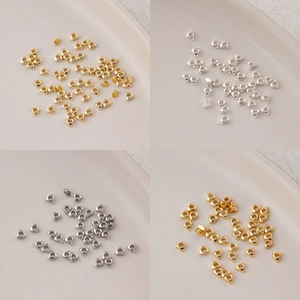 Dettaglio macro di perline triangolari lucide in oro e argento per la creazione di gioielli