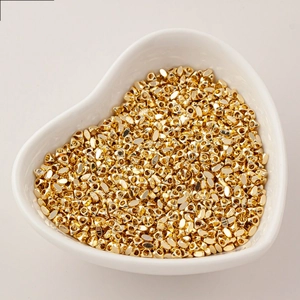 Perline in rame placcato oro in una ciotola di ceramica per creazione gioielli DIY