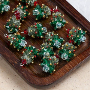 Macro detail of crystal Christmas tree pendants in a wooden tray for jewelry making