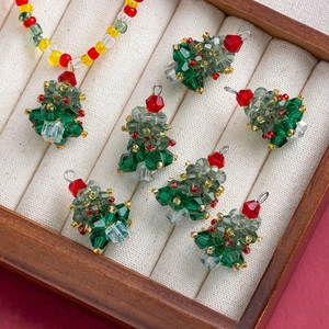 Macro shot of handcrafted crystal Christmas tree pendants with colorful beads in a wooden tray