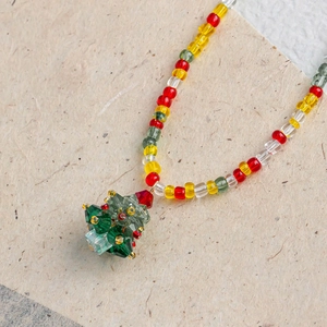 Macro detail of Christmas tree crystal pendant with festive colorful beaded chain