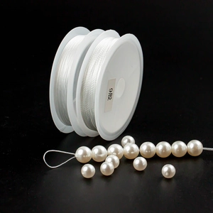 Detailed view of 9-strand white polyester thread stringing lustrous pearls for DIY jewelry