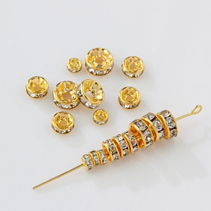 Detalle macro de cuentas espaciadoras rondelle bañadas en oro 18K con circón para joyería DIY