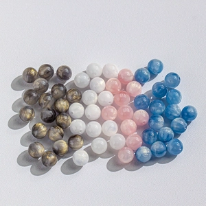 Macro shot of 8-10mm galaxy cat eye beads in pink, blue, and grey for DIY jewelry