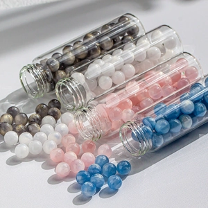 Macro view of blue and pink cat eye beads inside a glass tube for DIY jewelry making