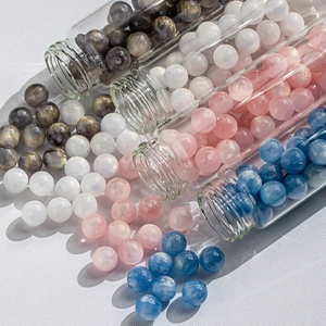 Macro detail of blue and pink cat eye star beads in glass tubes for DIY jewelry