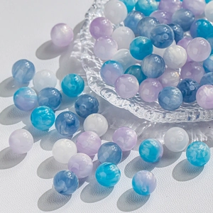 Vue macro de perles œil de chat colorées marbrées dans un bol en verre pour bijoux DIY
