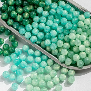 Macro shot of green and blue cat eye beads with gold glitter for DIY jewelry making