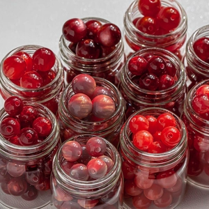 Assorted red 8-10mm resin beads in glass jars for DIY jewelry necklaces and bracelets