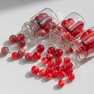 Polished red resin beads with gold gilding and small glass bottles for DIY jewelry making