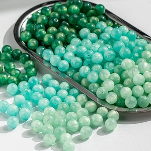 Mix of green and white cat eye glass beads with celestial gold dust finish for jewelry DIY
